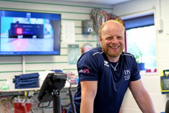 A member of the Sussexsport staff team smiles at the Sport Centre reception desk