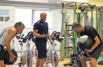 A Sussexsport instructor leads a circuits class while two men workout at the Sport Centre