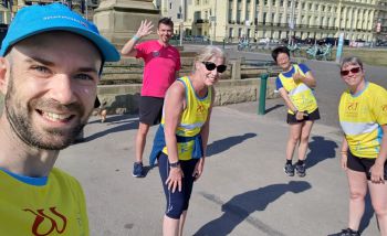 Five Team Sussex runners on Brighton seafront, wearing yellow vests or t-shirts