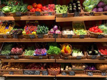 A wide variety of fruit and vegetables stacked on supermarket shelves