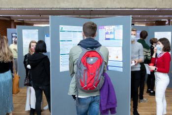 Students and visitors look at academic posters on display boards in Mandela Hall