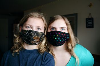 Stock photo of two people wearing colorful face coverings