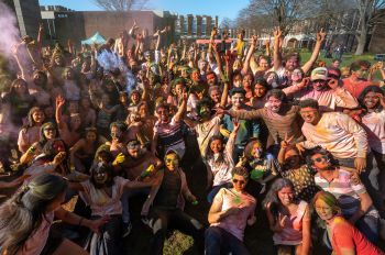 A large group of students covered in colour powder posing for the photo