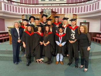 Social Work BA graduates and their Jersey course tutors following their graduation ceremony in a formal setting