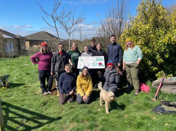 A group of volunteers and Sussex researchers installing and presenting the new pollinator signs, guides and bee hotels