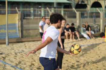 Man serves at 2023 Staff Volleyball Tournament