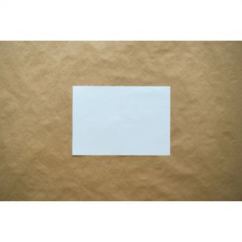 a blank white card against brown paper background
