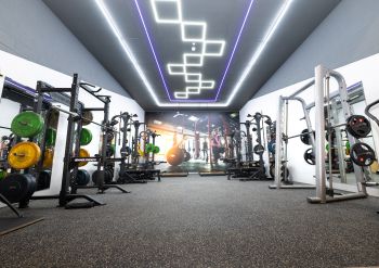 A photo of the new University of Sussex gym located in the Sports Centre. Photo shows gym equipment and colourful lighting.