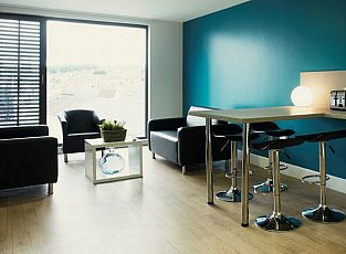 Photo of a modern kitchen in Abacus House, including a seating area and breakfast bar, and a large window with a stunning view of the city.