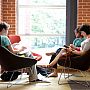 Students sitting in easy chairs inside the Library