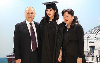 A graduate with her family at an overseas celebration