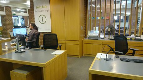 Member of Staff sitting at the Library Info Hub