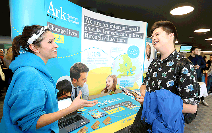 A student talking to a potential employer at a University of Sussex careers fair