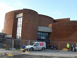 Exterior of the Attenborough centre behind a fence. Building work clearly about to start.