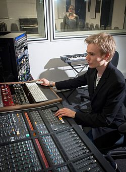 Someone operating the console in a music studio