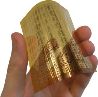 A picture of a hand bending a plastic sheet, on which circuits are printed