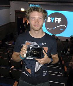 A photo of undergraduate filmmaker Sebastian Cox with his award from Brighton Youth Film Festival