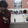 A student playing a fiddle with Falmer House courtyard in the background