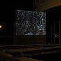 Film images projected onto the brickwork of the Meeting House at night