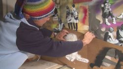 A spraypaint artist works on a giant mural of the University campus