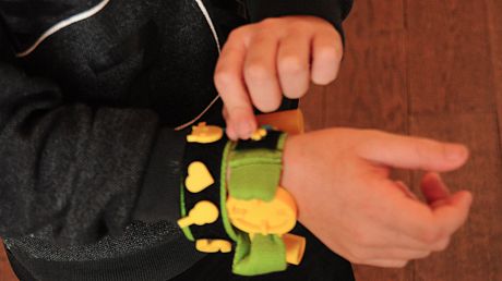 Picture of a child manipulating a wrist wearable device.