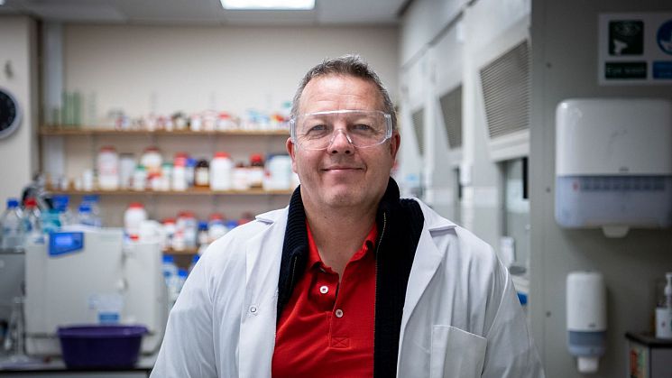 Professor John Spencer, Director of the Drug Discovery Centre at Sussex standing in front of the Arundel Building sign on campus