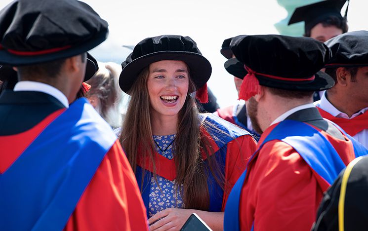 Dr Rosemary Coogan with two fellow graduates on Brighton seafront at summer graduation