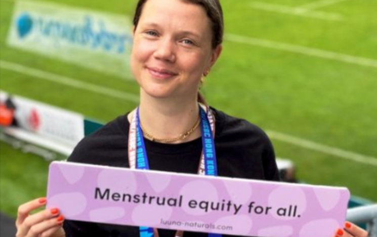 Poppy Hardy holding up a sign that read 'Menstrual equity for all'.