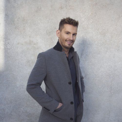Liam Hackett in grey coat, smiling