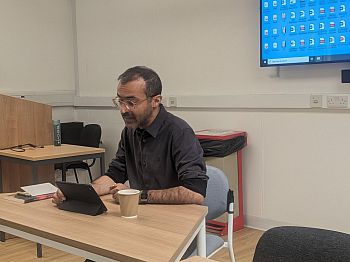 Photo showing a presenter at the PhD workshop talking about their research