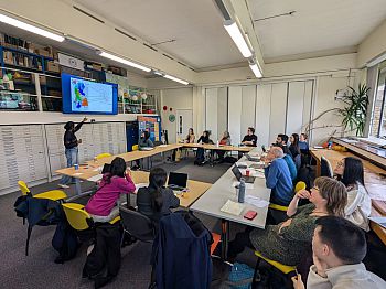 Photograph of attendees at the PhD workshop, listening to a speaker present a Paper