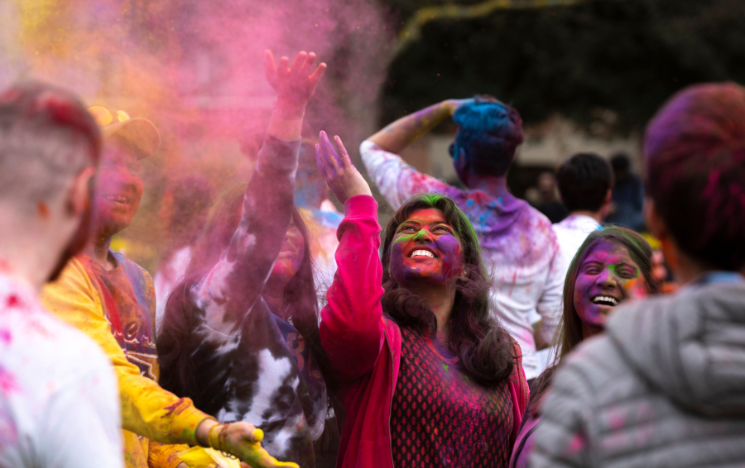 Students participating in Holi festival, throwing colourful powder paint