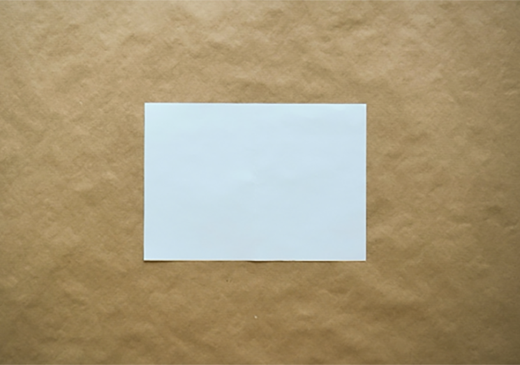 Photo of a blank a4 paper on brown paper.