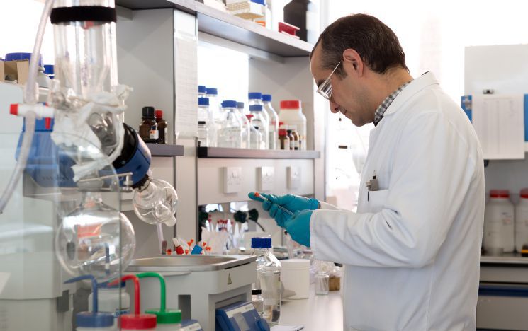 An academic working on a machine in a lab