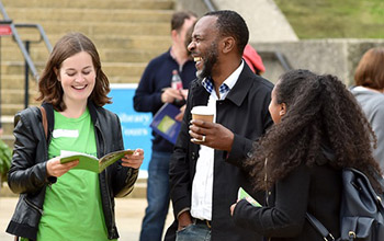 Three people laughing while in conversation