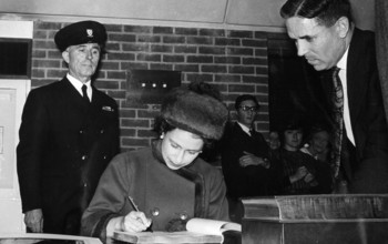 The Queen signing a document at the University of Sussex