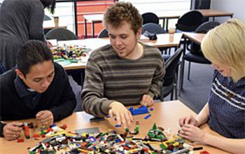 Three people building with lego at the University of Sussex