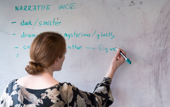 An academic writing on a whiteboard at the University of Sussex