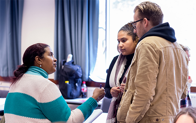 Students talking to a tutor at the University of Sussex