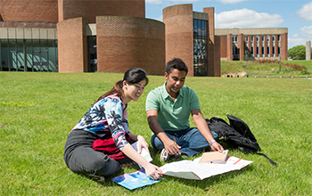 Students studying in the sunshine outside Attenborough Centre for the Creative Arts on campus at the University of Sussex