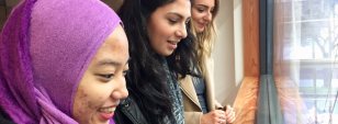 Three female social work students look into the distance in a University building