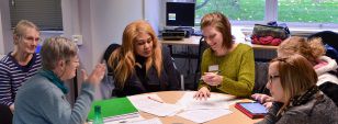 A group of social work students sit around a classroom table
