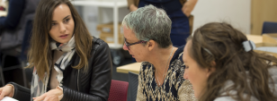 three students discuss a project in a classroom