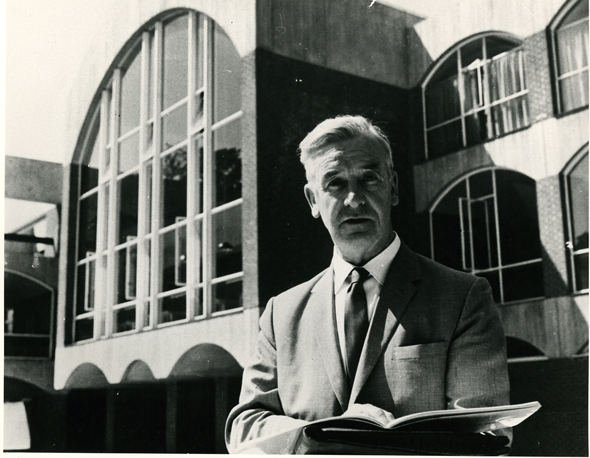 Black and white archive photograph of John Fulton standing in front of Falmer House.