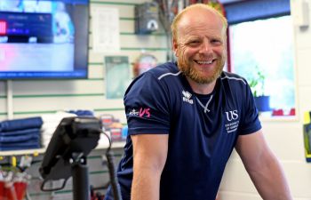 A member of the Sussexsport staff team smiles at the Sport Centre reception desk