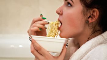 A woman prepares to eat some noodles