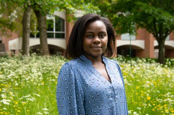 Tamanda Maggie Gomani, Mandela Scholar, in front of grass and a red brick Sussex campus building