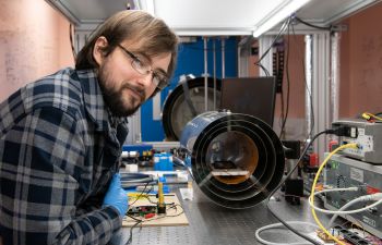 Thomas Coussens in the quantum lab looks at the camera