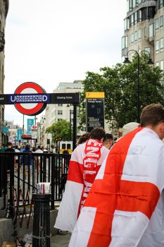 Football fans wearing England flags near an Underground station in London