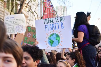 A large group of climate protesters hold up signs